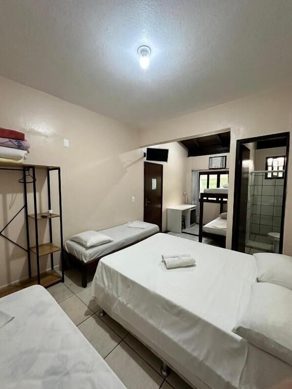 A hotel room with two single beds, a small desk, a mirror, and a wardrobe. - Hotel D luz (Itapema)