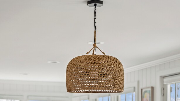 A dining area with a wooden table, woven chairs, and a hanging woven light fixture. - Ocean Views! Walk to Beaches! 4BR Vacation Retreat (Kennebunk)