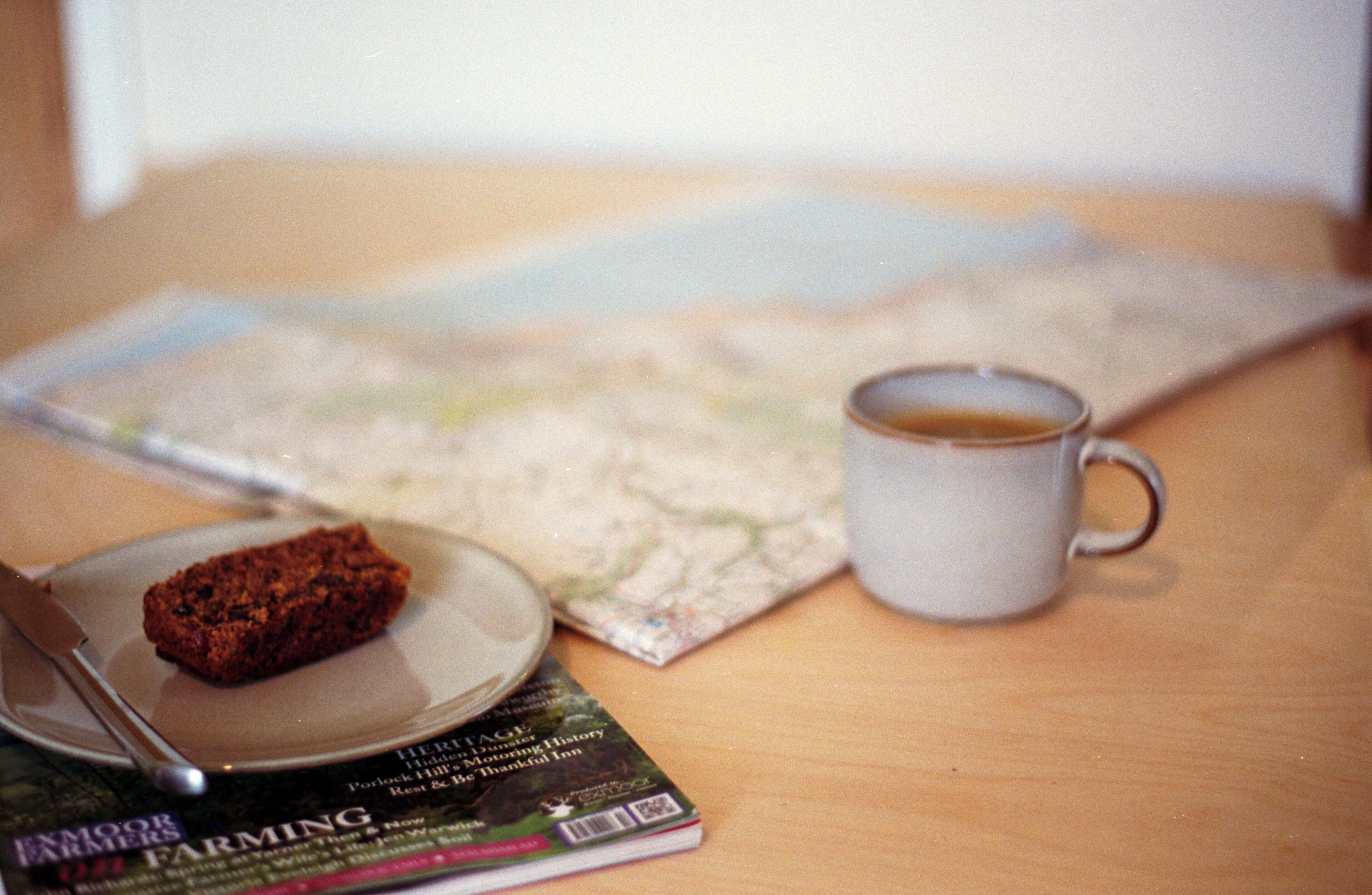 A map, a mug, a knife, and a book on a table.