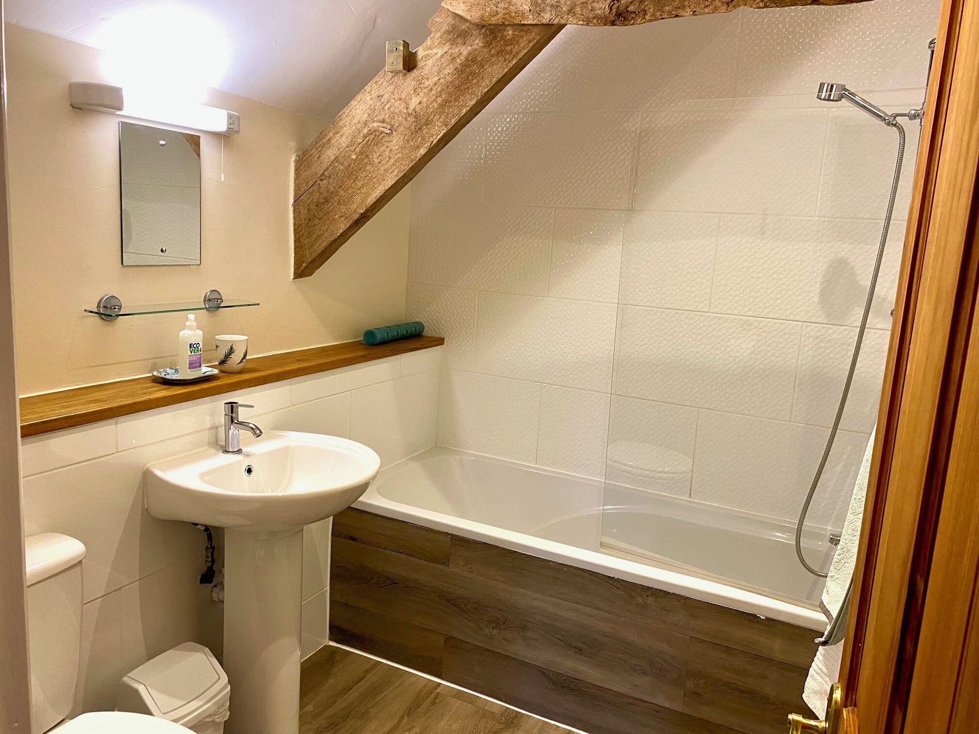 Une salle de bain comprenant un lavabo, des toilettes et un espace douche.