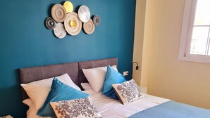 A bedroom with a bed, pillows, a bedside table, a rug, and wall decor. - 🌴 **Luxury Coastal Getaway – 2 Bed, 2 Bath Apartment with Pool Views** 🌴
 (Manilva)