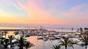 A marina with numerous boats docked, a lighthouse, and a building with balconies. - 🌴 **Luxury Coastal Getaway – 2 Bed, 2 Bath Apartment with Pool Views** 🌴
 (Manilva)
