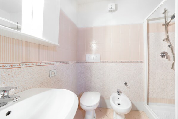 A bathroom with a sink, toilet, bidet, and shower. - Two-bedroom, two-bathroom apartment with pool and AC (Toscana)