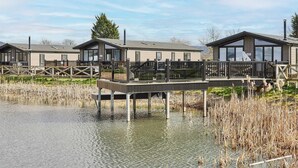 A lakeside property with multiple cabins, a dock, and a grassy area. - Host Stay River Tees Lodge (Middlesbrough)