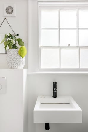 A white bathroom with a window, a white sink, and a potted plant. - Central Georgian Townhouse With Free Parking (Bath)