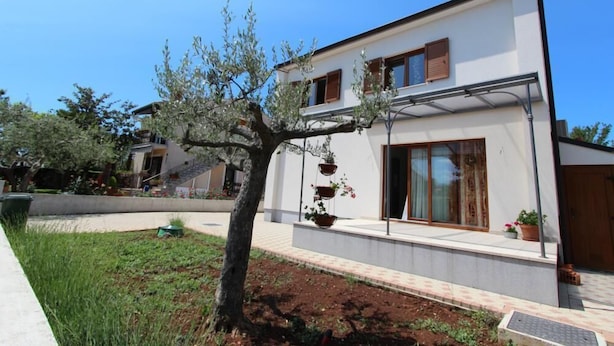 A modern two-story house with a white exterior, large windows, and a small tree in the front yard. - Studio Rovinj Home (Rovinj)