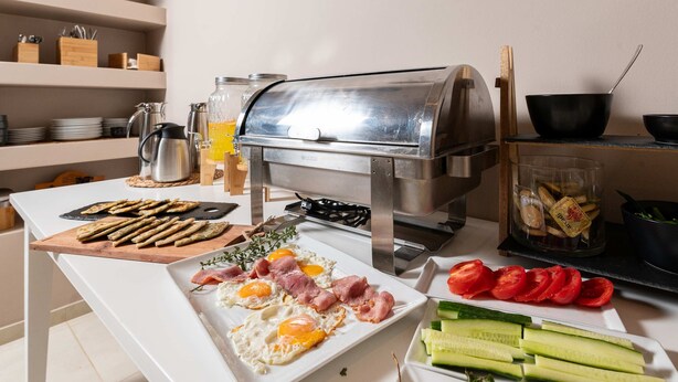 A breakfast setup with eggs, bacon, tomatoes, cucumbers, and toast. - Mear Luxury Studio - Crete Garden Gem (Kantanos-Selino)