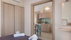Une chambre d’hôtel moderne équipée d’un lit, d’une salle de bain et d’une kitchenette.