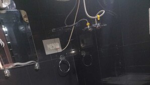 Un baño con un lavamanos blanco, un cubo azul y un inodoro.