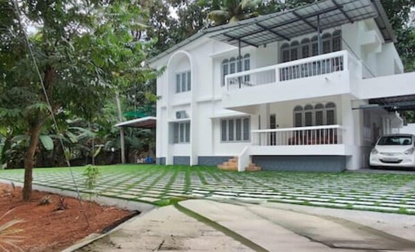 Stunning two-story home surrounded by lush greenery and a well-manicured lawn.