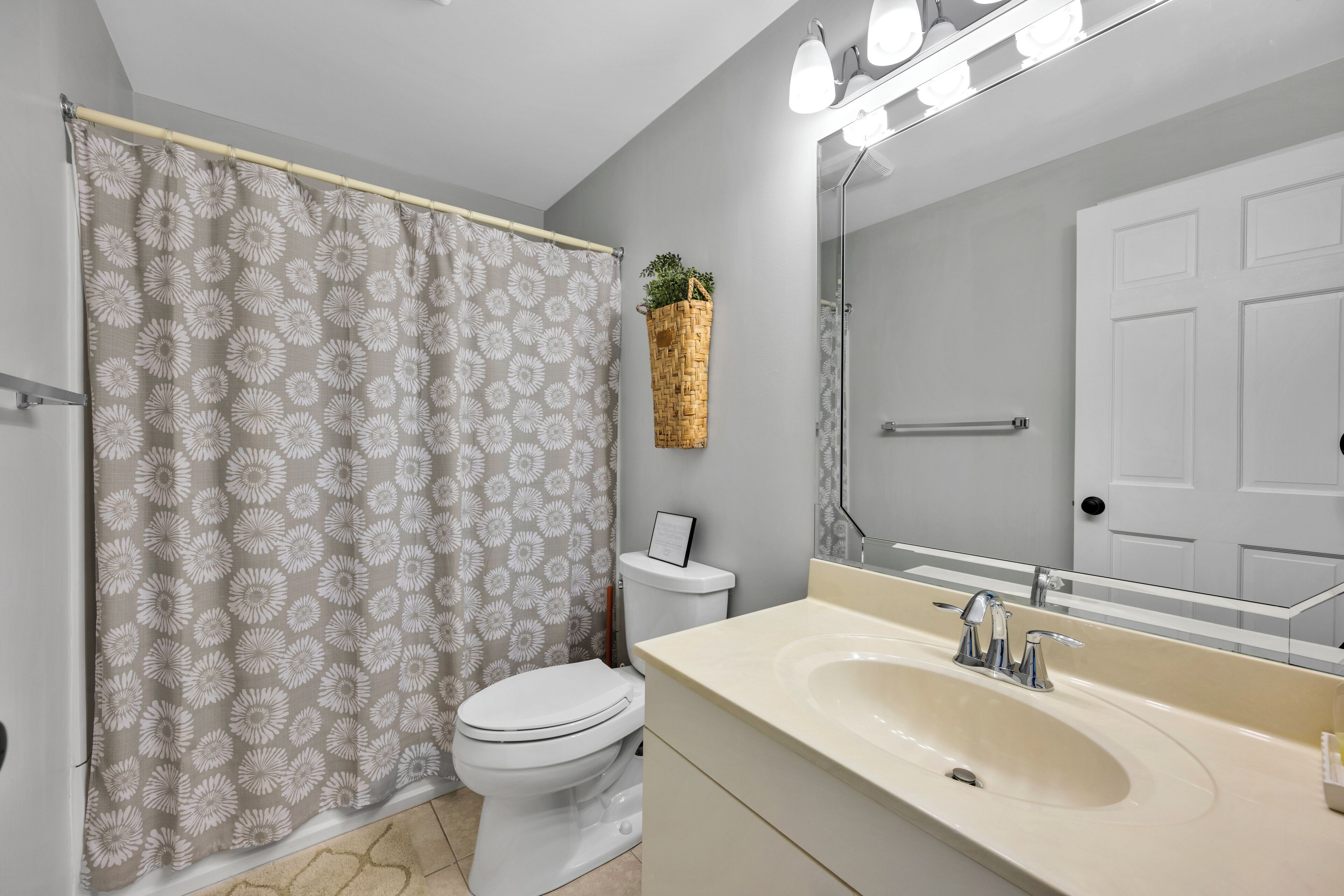 A bathroom with a toilet, sink, and mirror.