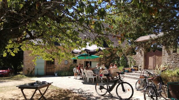 Eine Außenpatio-Terrasse mit Steinmauern, einem Tisch mit Gegenständen darauf und in der Nähe abgestellten Fahrrädern.