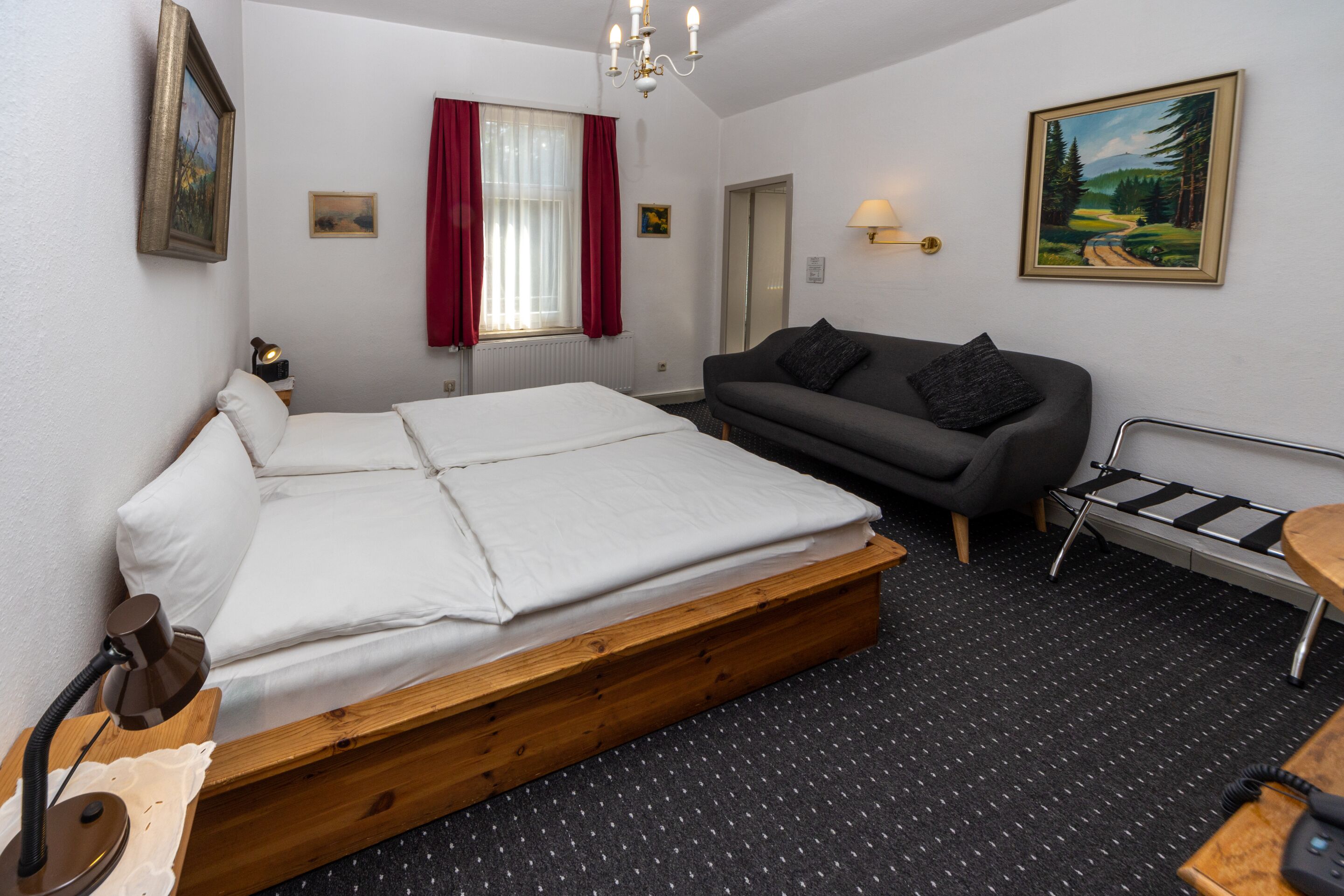 Um quarto com uma cama, um sofá, uma escrivaninha e uma cadeira.