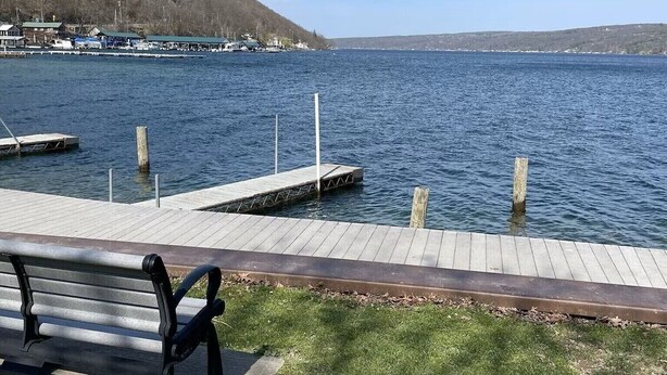 A waterfront park with a wooden dock and a bench.