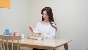 Una persona sentada a una mesa con una taza, un plato y una caja de pañuelos.