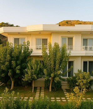 Un bâtiment moderne à deux étages, doté d’un toit plat, de grandes fenêtres et d’un balcon à l’étage supérieur.