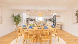 Un espace repas moderne avec une table ronde en bois, des assiettes bleues et des chaises en osier.