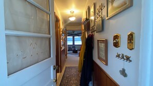 A hallway with a patterned rug, wooden walls, and a door with frosted glass panels. - Idyllic 3-Bedroom Lake Front Cottage on Ford Lake (Fountain)
