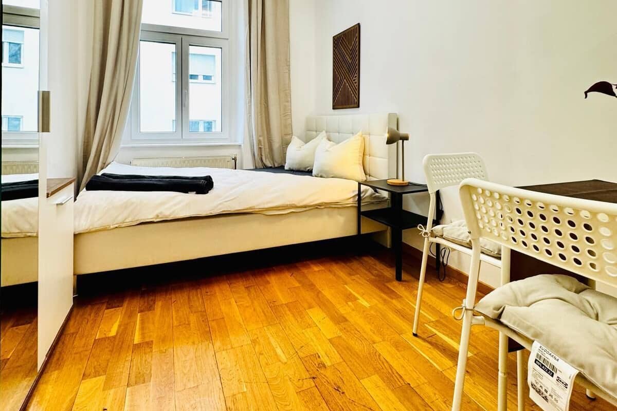 Una habitación pequeña con cama, escritorio y silla.