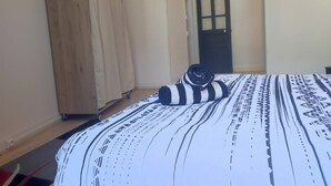 Une chambre à coucher comprenant un lit, une armoire et une porte donnant sur une autre pièce.