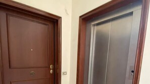 Una habitación con una puerta de madera y un ascensor metálico.