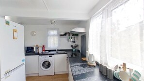 Een koelkast, een magnetron, een oven, eettafels