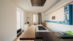 A modern kitchen with a long countertop, built-in appliances, and a window providing natural light. - Casa Santa Sofia con Terrazza by Wonderful Italy (Palermo)