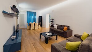 A modern living room with a sofa, coffee table, and a TV stand. - Casa Santa Sofia con Terrazza by Wonderful Italy (Palermo)