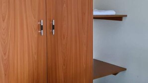 A wooden wardrobe with two doors and a shelf above it. - BLT Guest House, Kasese (Kasese)