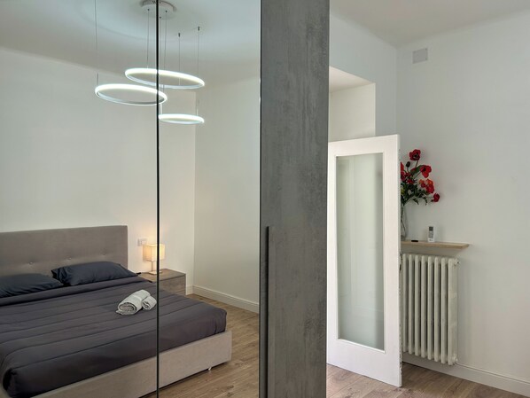 2 habitaciones, escritorio y tabla de planchar con plancha