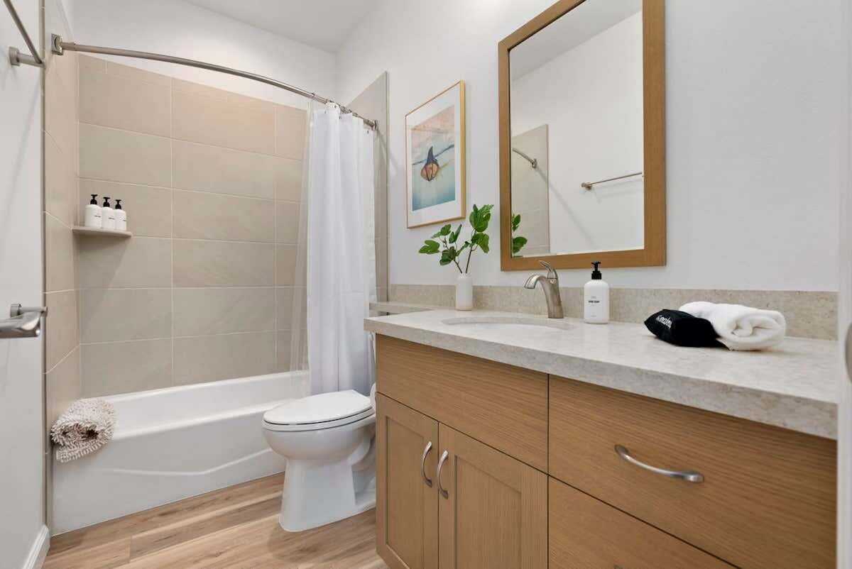 Een moderne badkamer met een douche, toilet en wastafel.