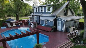 A backyard with a swimming pool, deck chairs, a barbecue area, and a house with a gabled roof. - The Vintage on Market, w/Pool, near Hershey, Ironstone Ranch & Spooky Nook (Elizabethtown)
