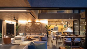 A modern living room with a sectional sofa, a coffee table, and a dining area with a table and chairs. - Villa Mariposa - Brand New - 7 Bedroom 8.5 Bath - Peninsula Papagayo (Peninsula Papagayo)