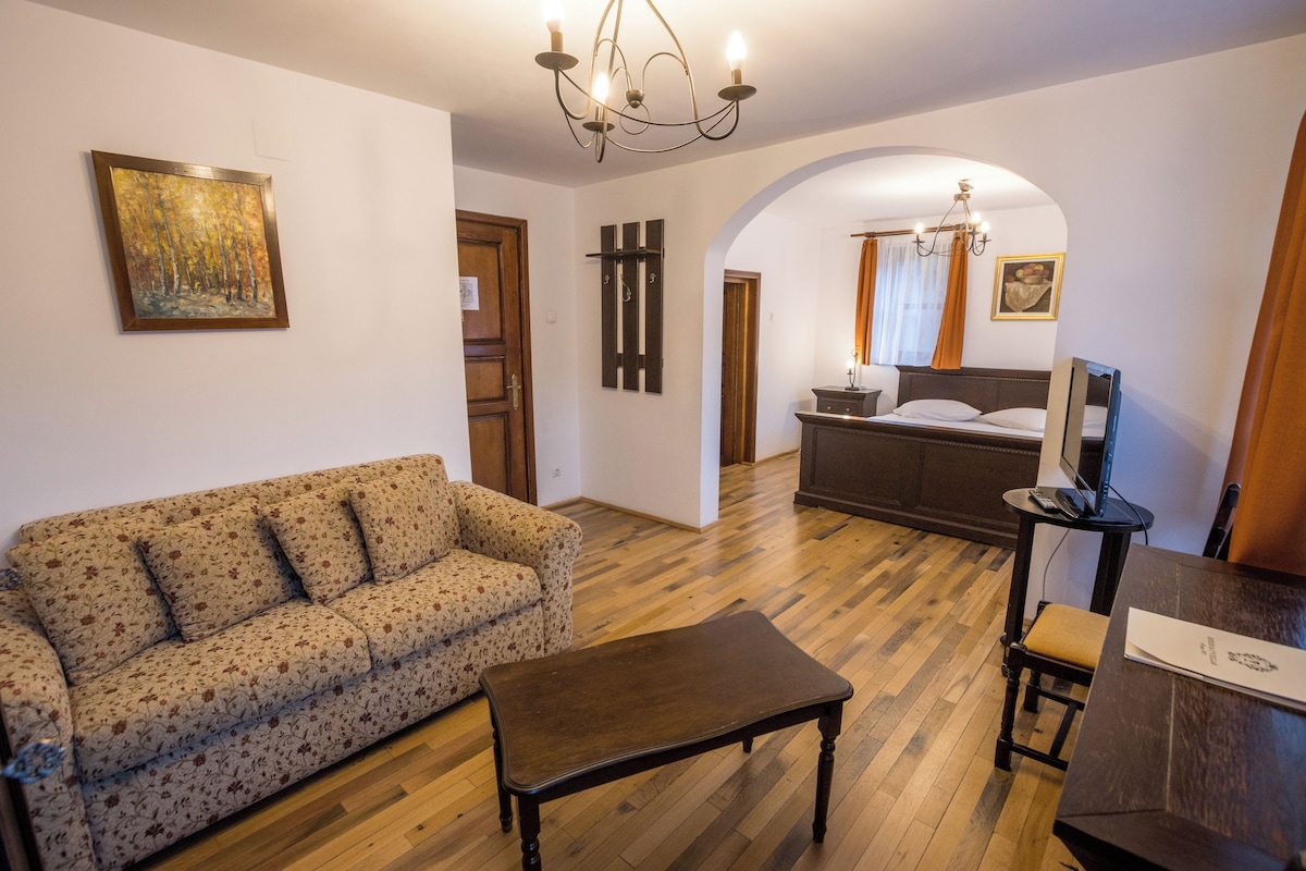 Una sala de estar con sofá, mesa de centro, televisor y zona de comedor.