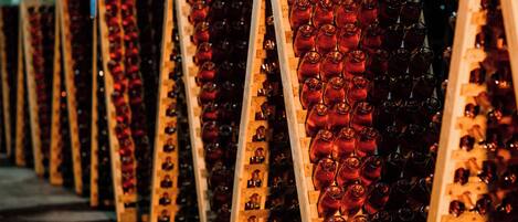 Rows of wooden racks holding numerous bottles.