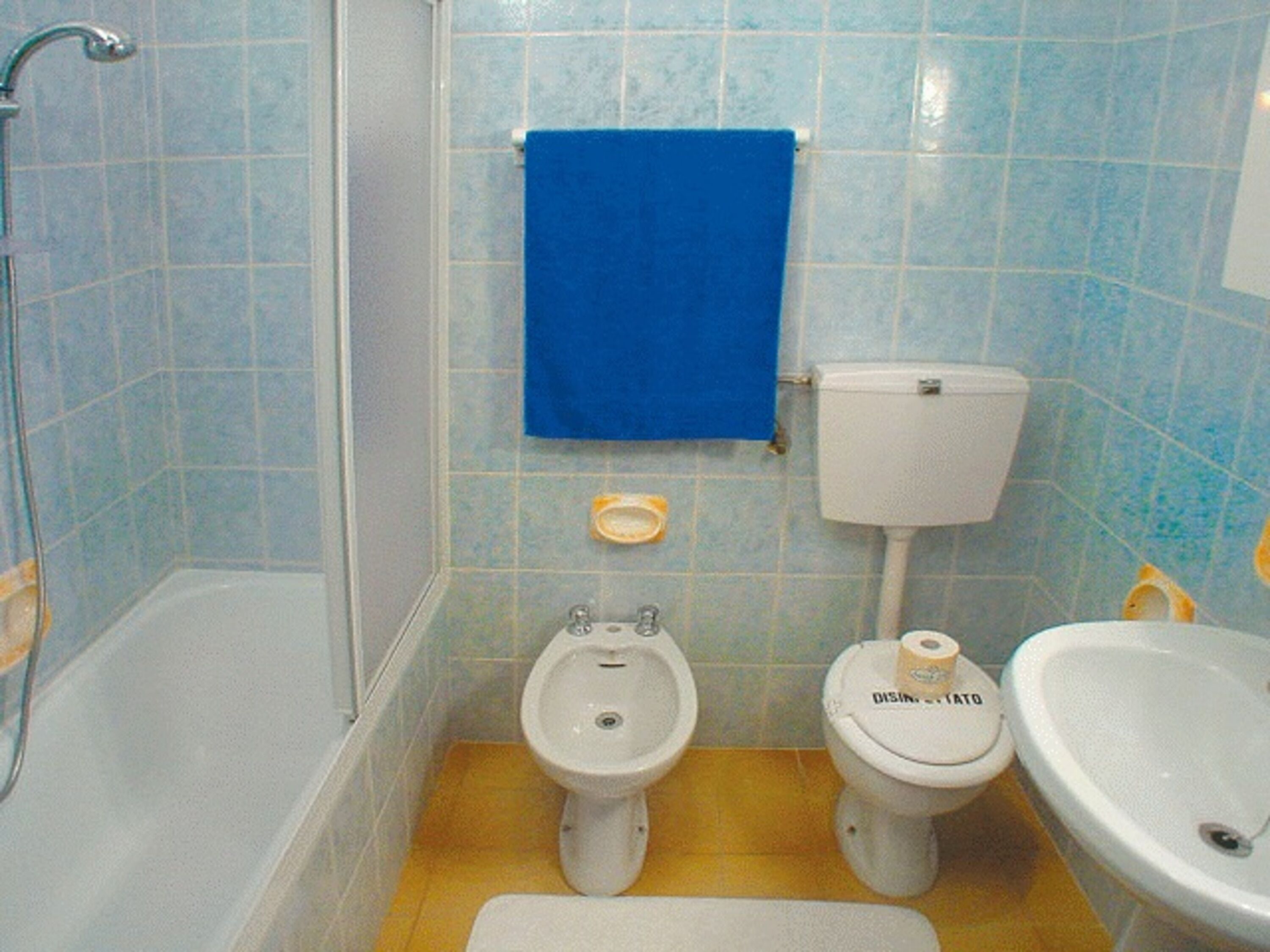 A bathroom with a bathtub, a bidet, a toilet, and a sink.