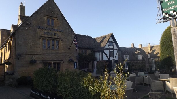 Un edificio de estilo Tudor tradicional con un letrero que dice "Broadway Hotel".