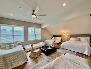A bedroom with two beds, a ceiling fan, and a large window. - Luxury Spacious ATL Mansion. up to 18 beds 5 Bath, pool & sauna. near Piedmont (Atlanta)