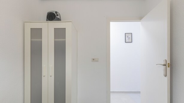 A room with a wardrobe, a bed, and a door leading to another room. - 2-bedroom Apartment-close to Beaches and Center (Torrevieja)