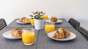 A breakfast setting with croissants, orange juice, and a coffee cup on a table. - 2-bedroom Apartment-close to Beaches and Center (Torrevieja)