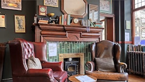 A traditional room with leather armchairs, a fireplace, and bookshelves. - The Carlton Tavern Hotel (London)