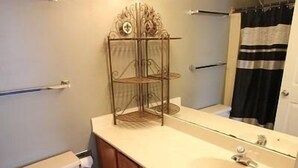 A bathroom with a toilet, sink, and vanity. - King Charles Avenue 408 #2 (Rehoboth Beach)
