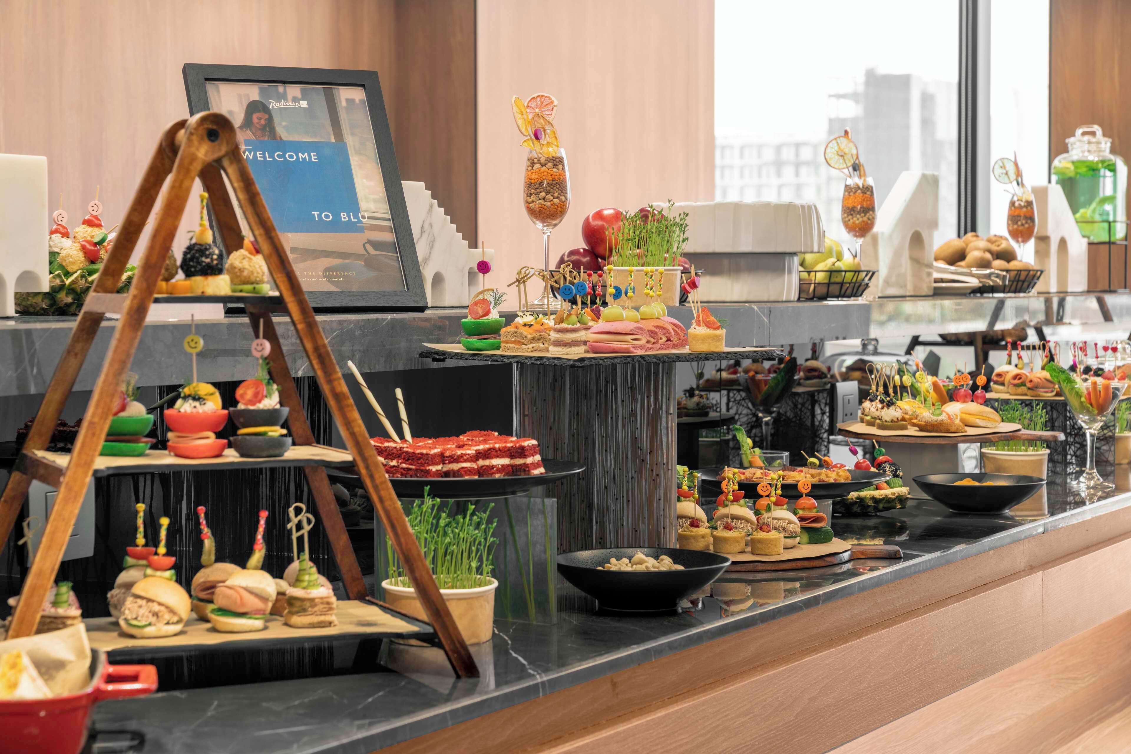 A buffet with various food items and a welcome sign.