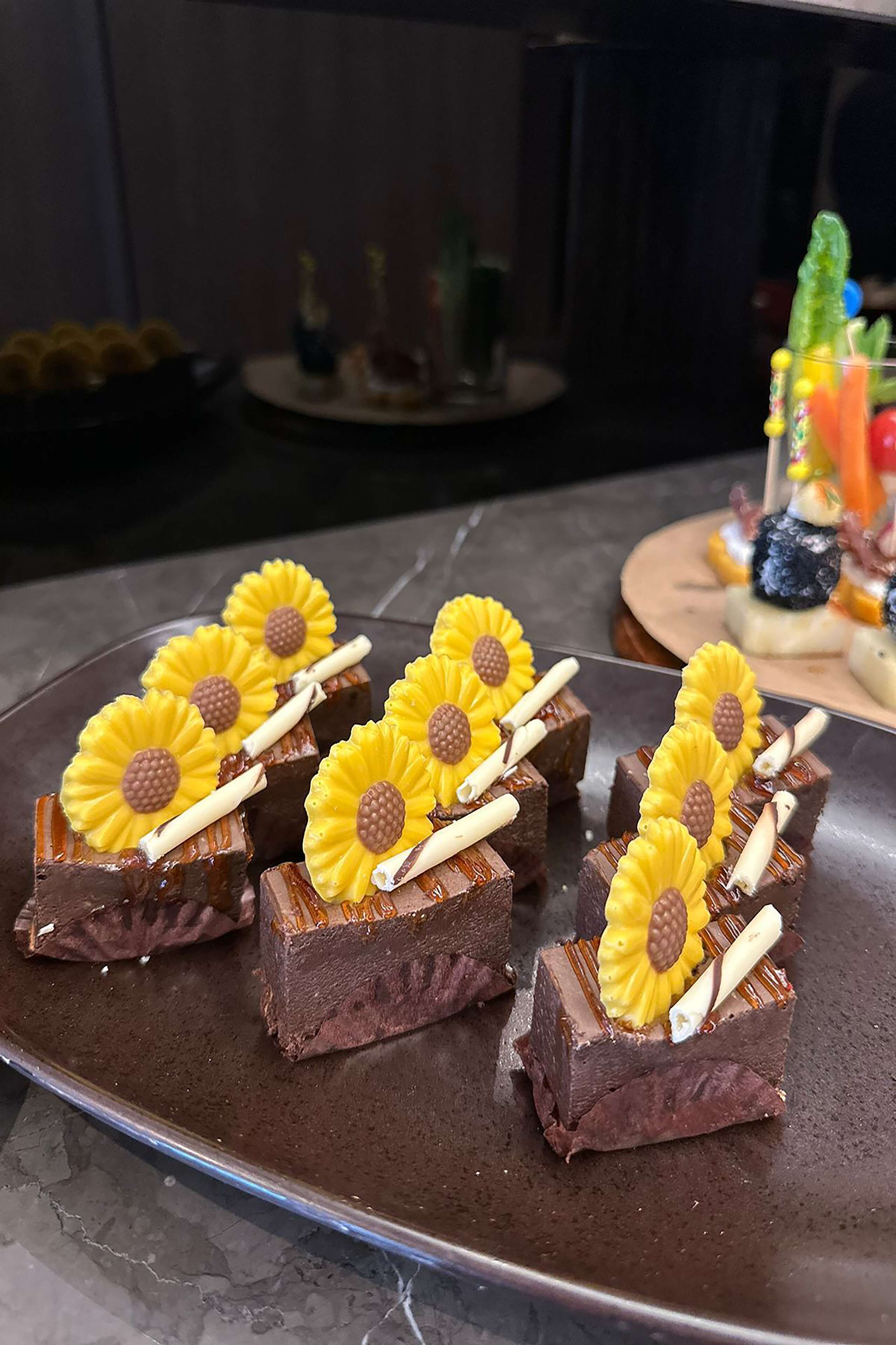 A plate of brownies with sunflower decorations.
