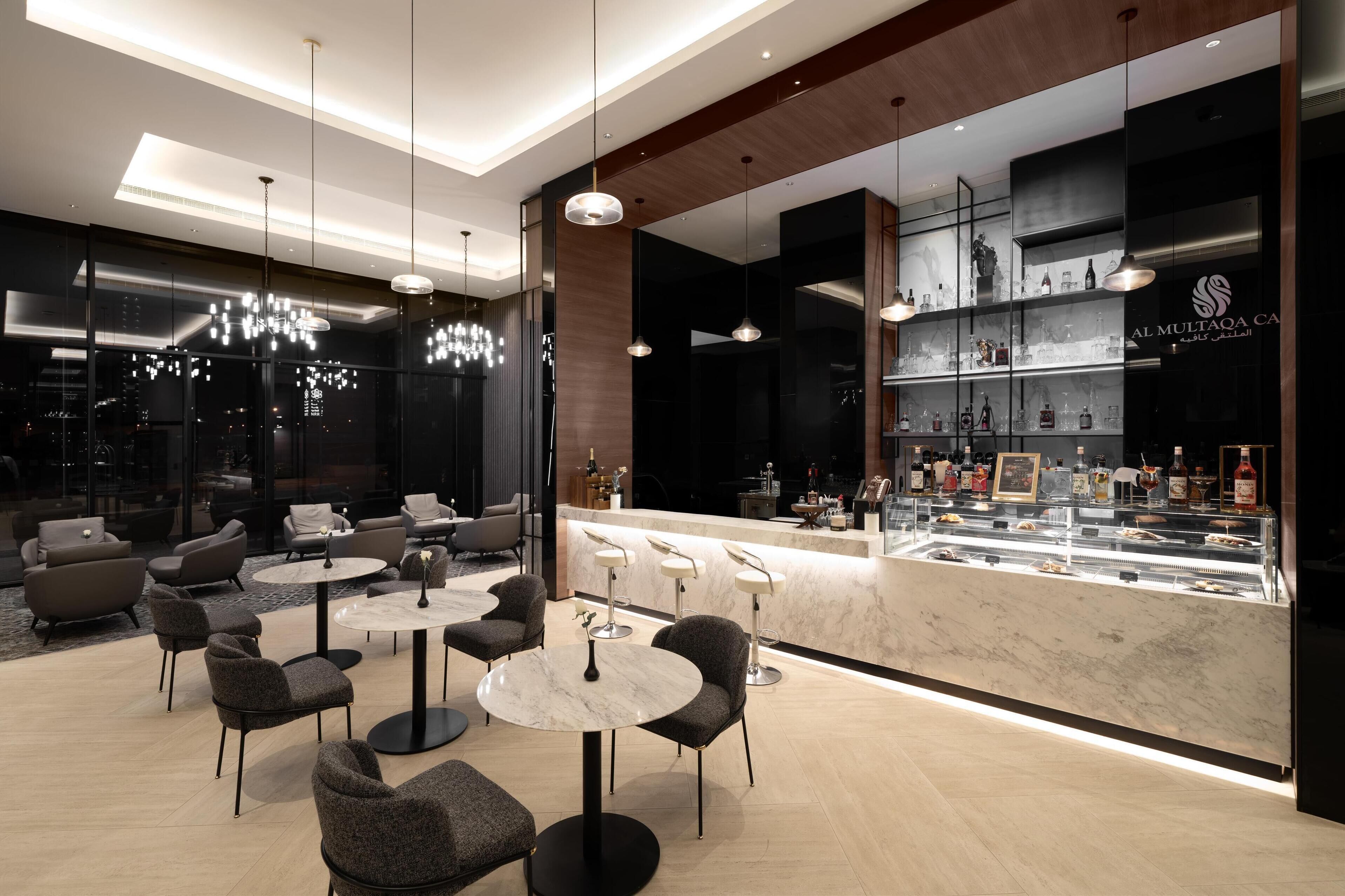 A modern bar area with marble countertops and a variety of liquor bottles.