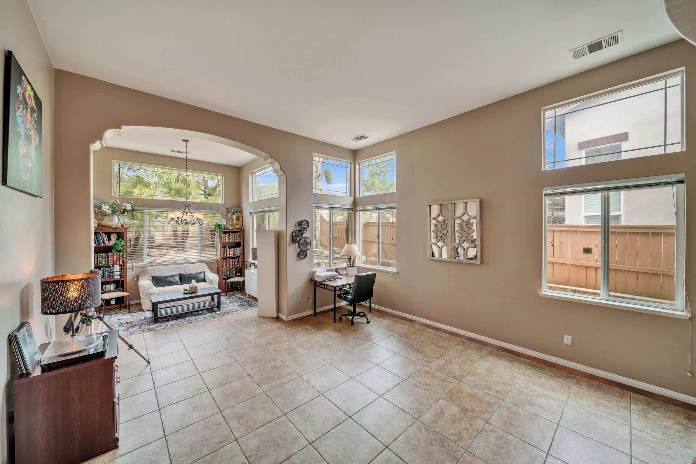 A spacious living room with a large window, a fireplace, and a cozy seating area.