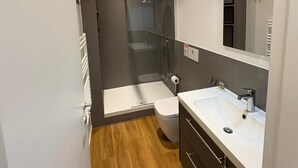 Ein modernes Badezimmer mit Dusche, Toilette und Waschtisch.