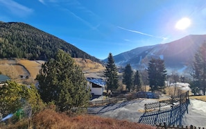 A mountainous landscape with a house, trees, and a fenced area. - House in Bad Kleinkirchheim by Ski Slope (Bad Kleinkirchheim)