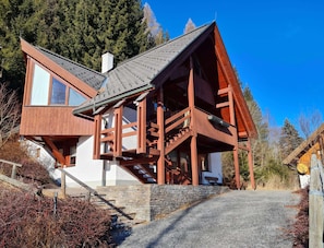 A wooden cabin with a stone foundation, a staircase leading to the entrance, and a clear view of the surrounding forest. - House in Bad Kleinkirchheim by Ski Slope (Bad Kleinkirchheim)