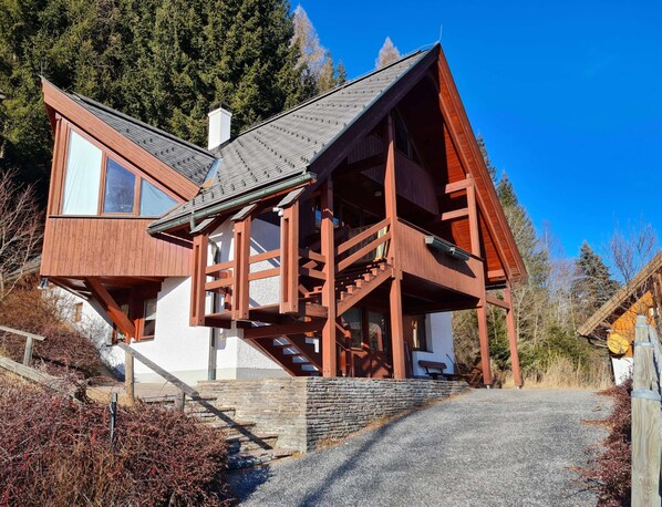 A wooden cabin with a stone foundation, a staircase leading to the entrance, and a clear view of the surrounding forest. - House in Bad Kleinkirchheim by Ski Slope (Bad Kleinkirchheim)